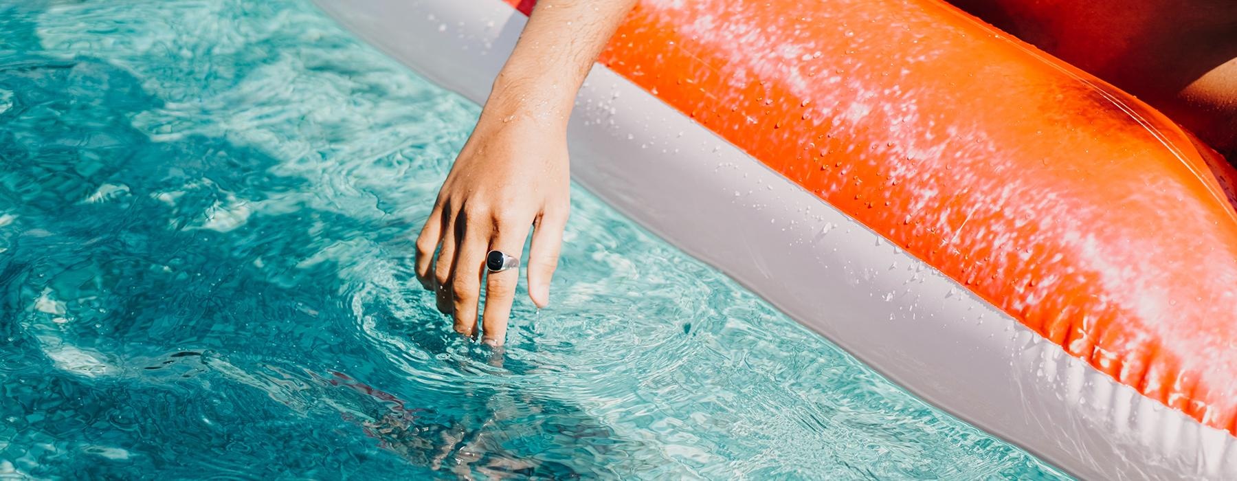 a persons arm sitting on a pool float